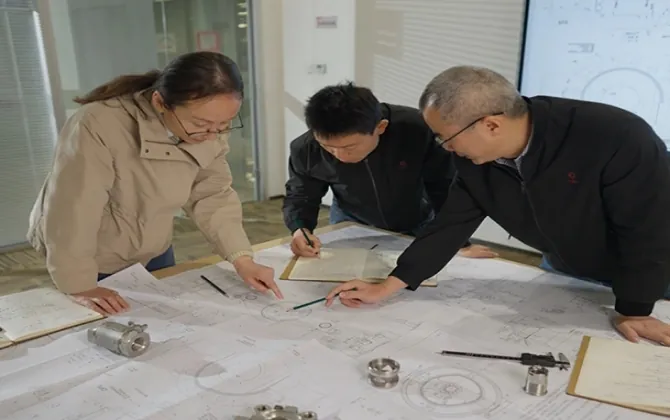Engineering team reviewing a replacement-part drawing
